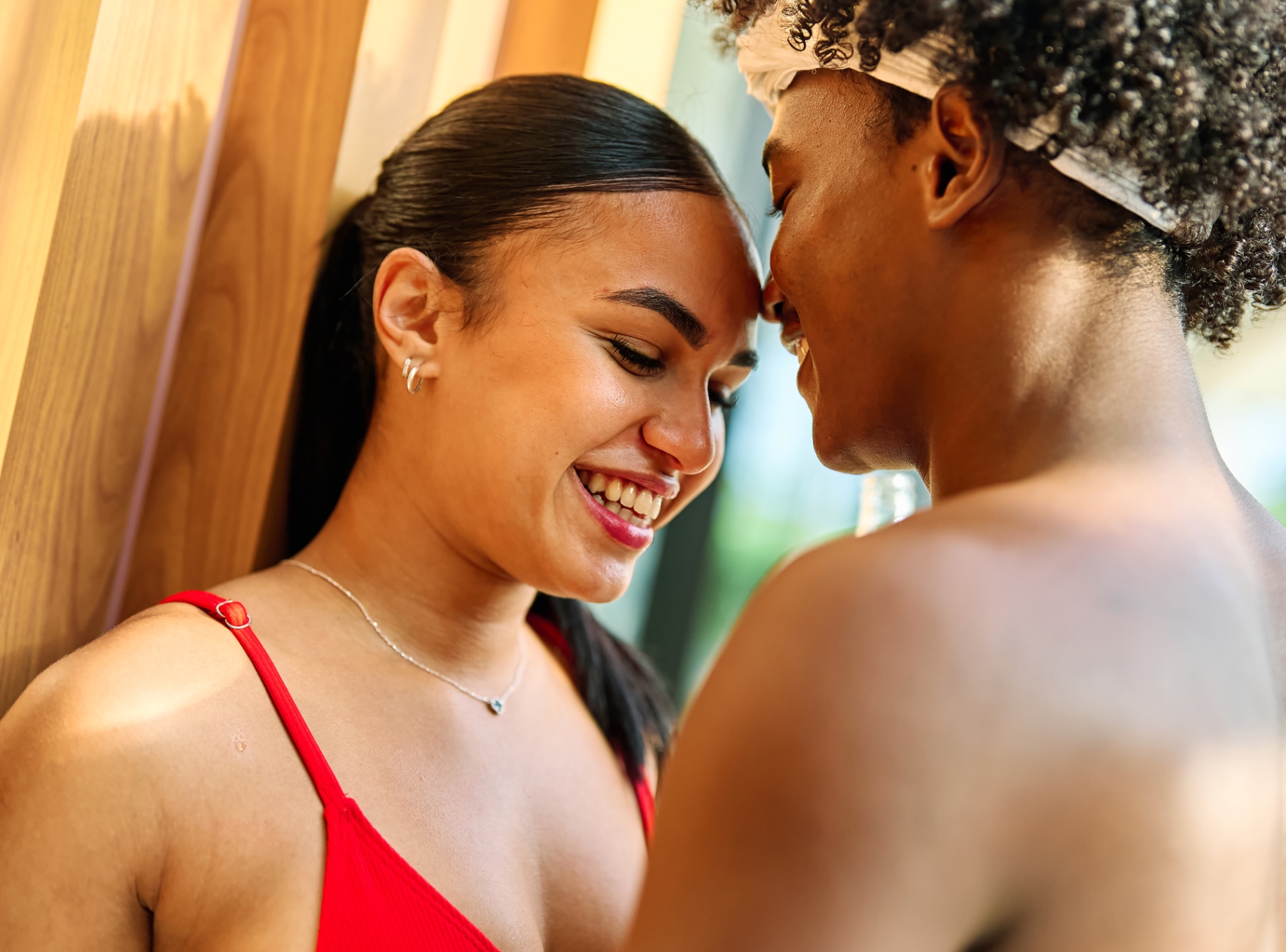 Two women smiling with their foreheads touching