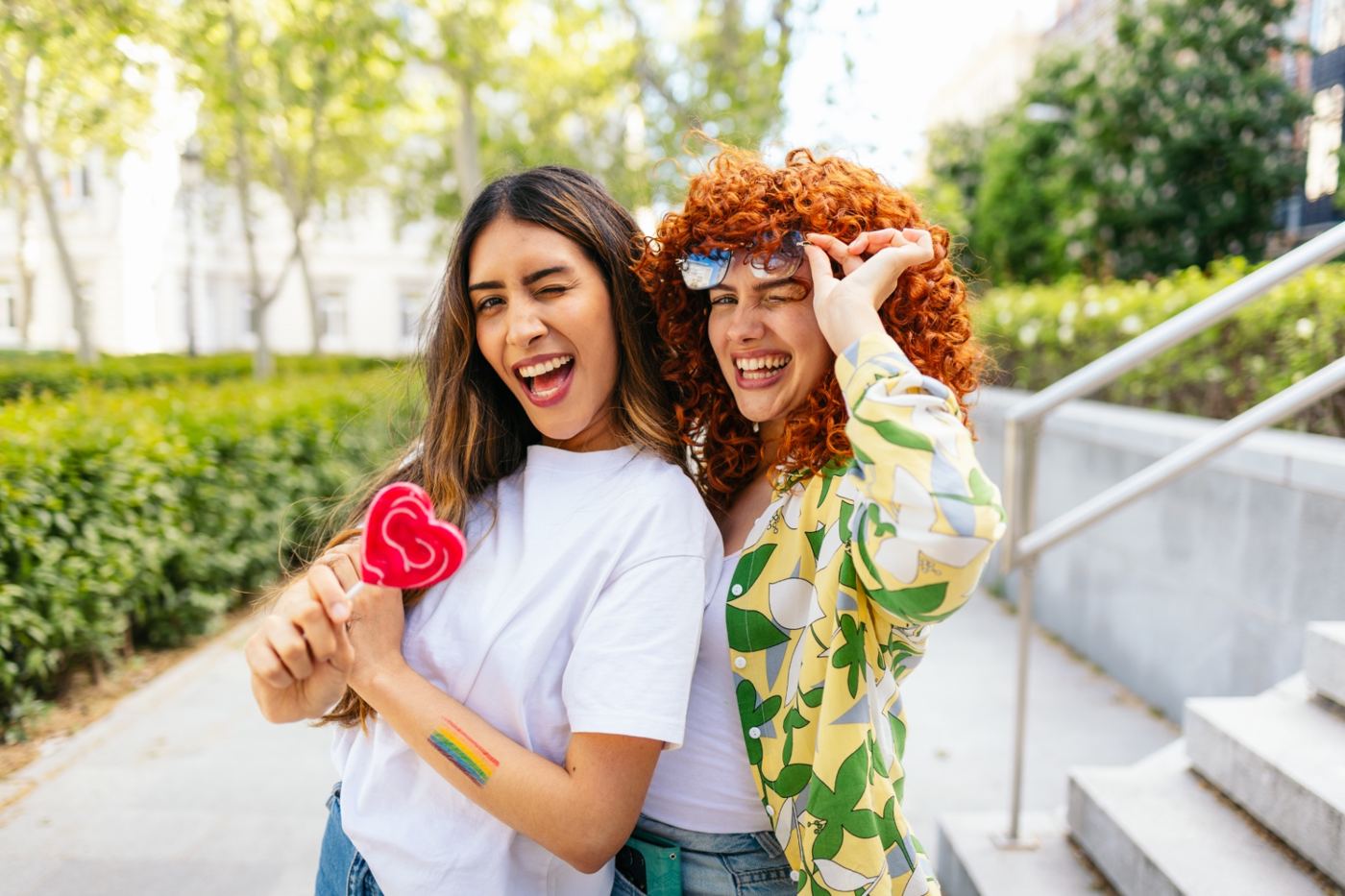 Two friends laughing together on a sunny street